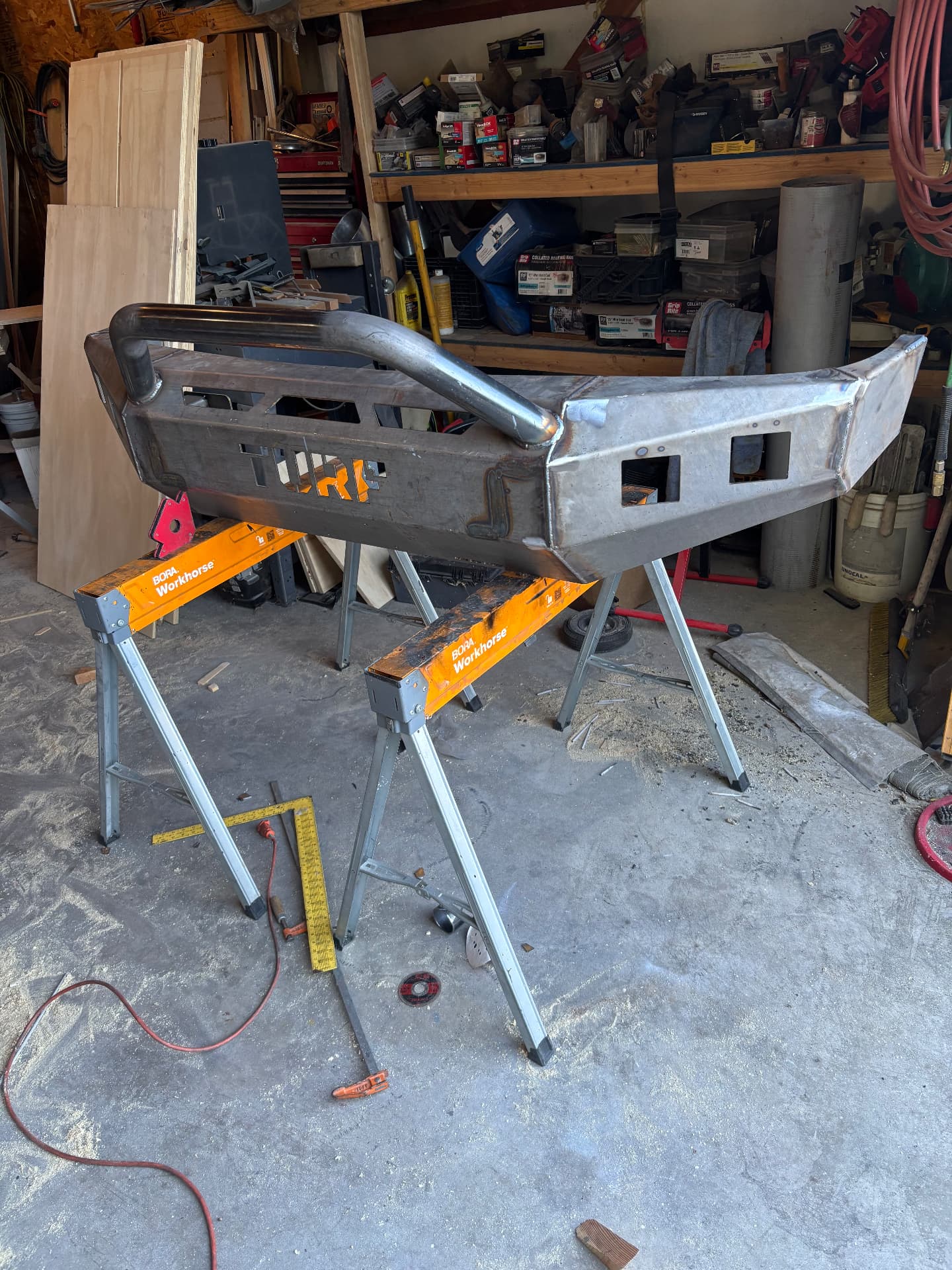 Custom fabricated steel truck bumper with tube bar on stands in the shop