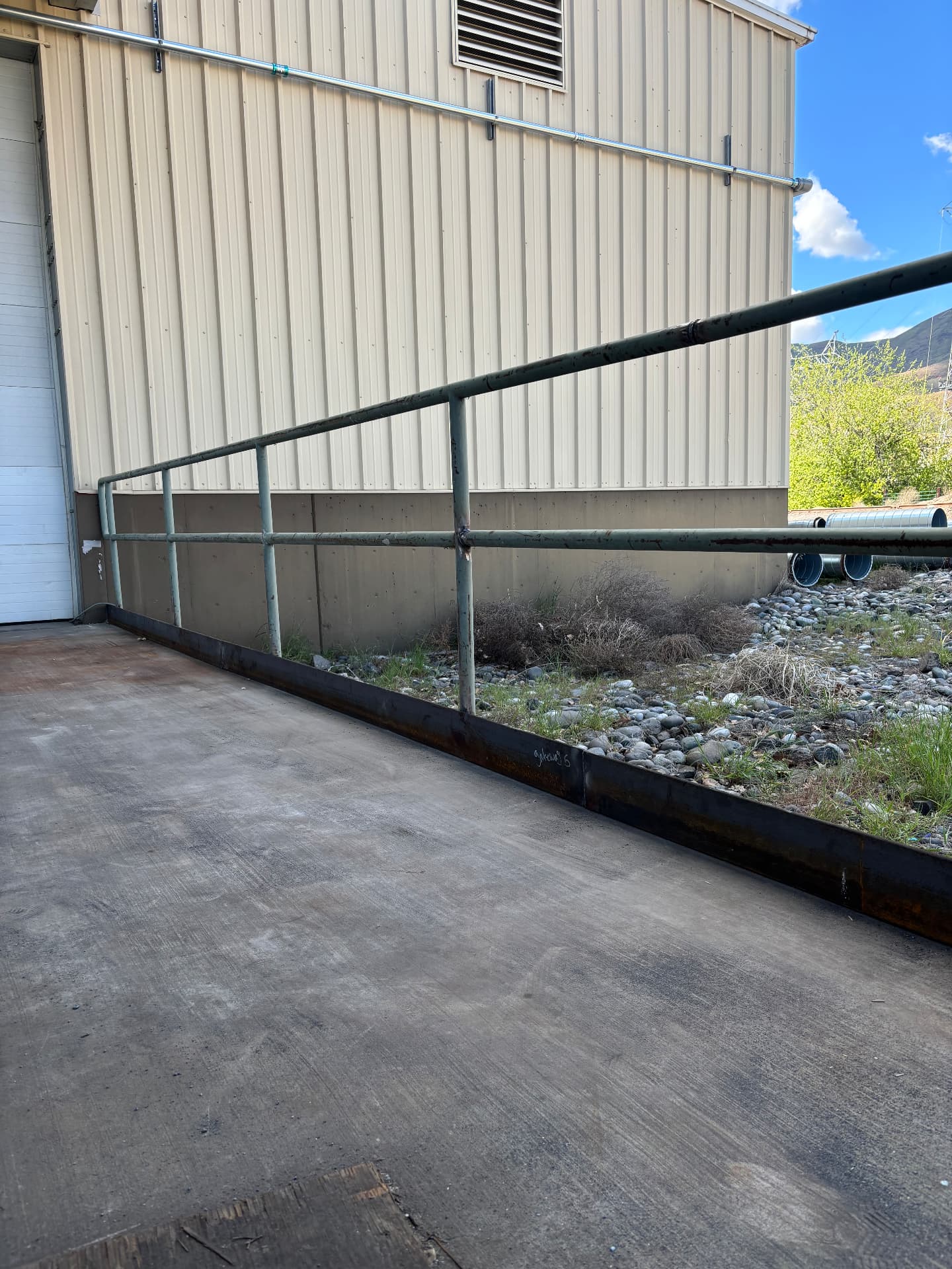 Pipe handrail and steel ramp edge at a loading dock
