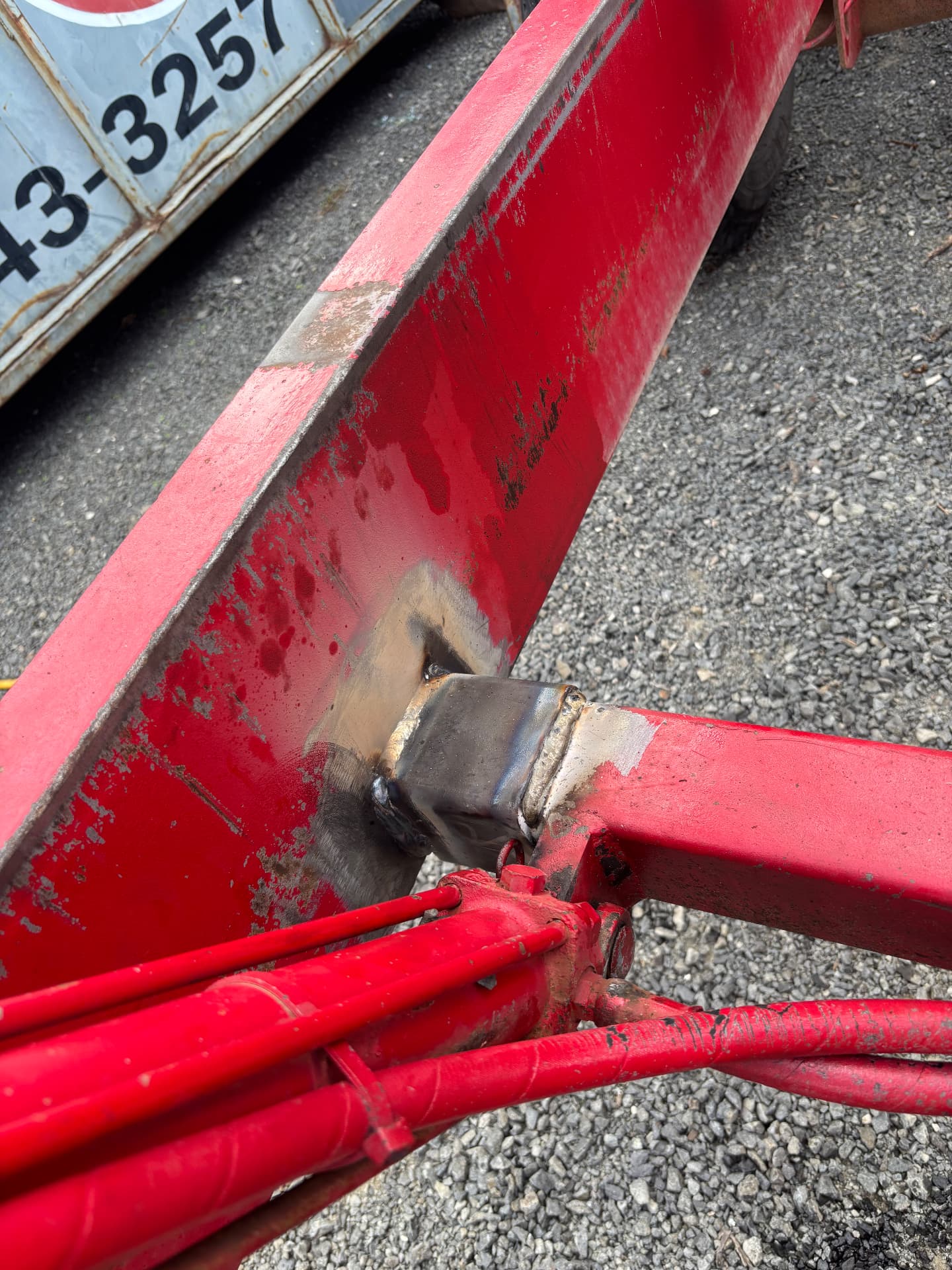 Square tube section welded into a damaged area of red farm equipment