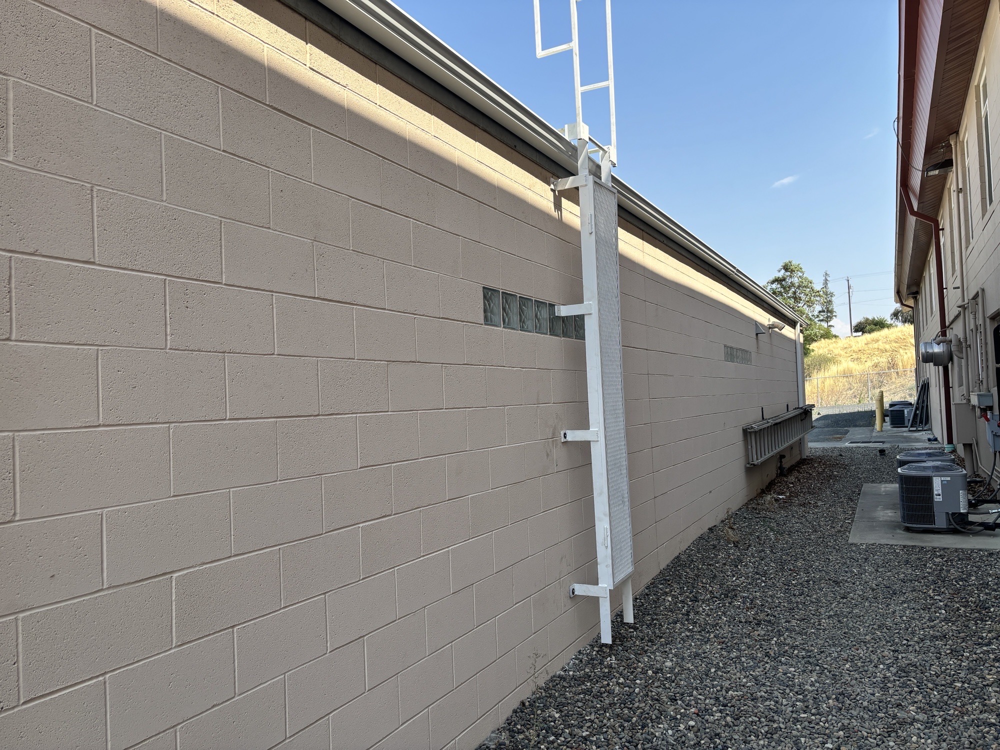 Roof access ladder leading onto a commercial rooftop