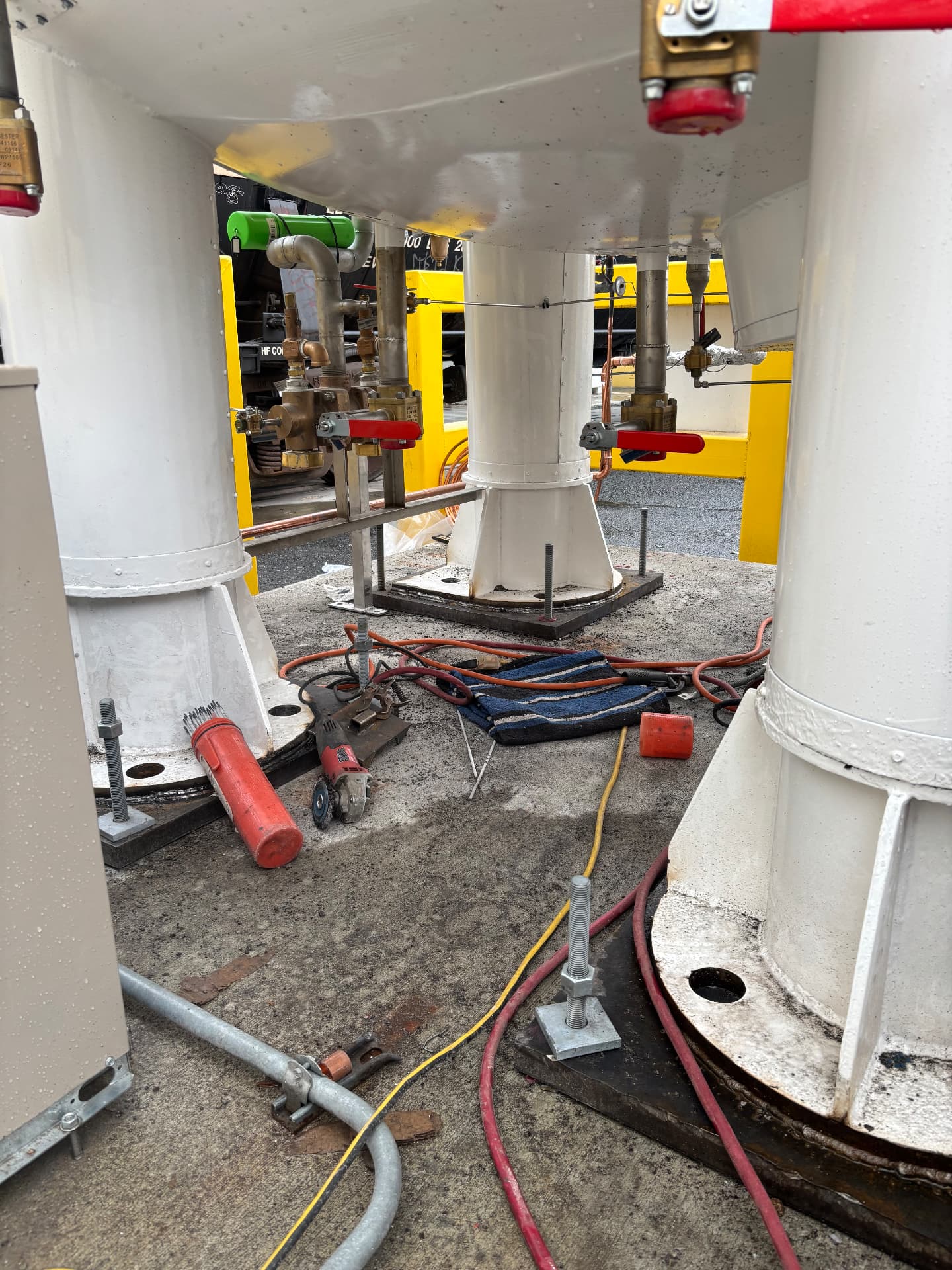 Valve and piping components beneath an industrial tank during installation